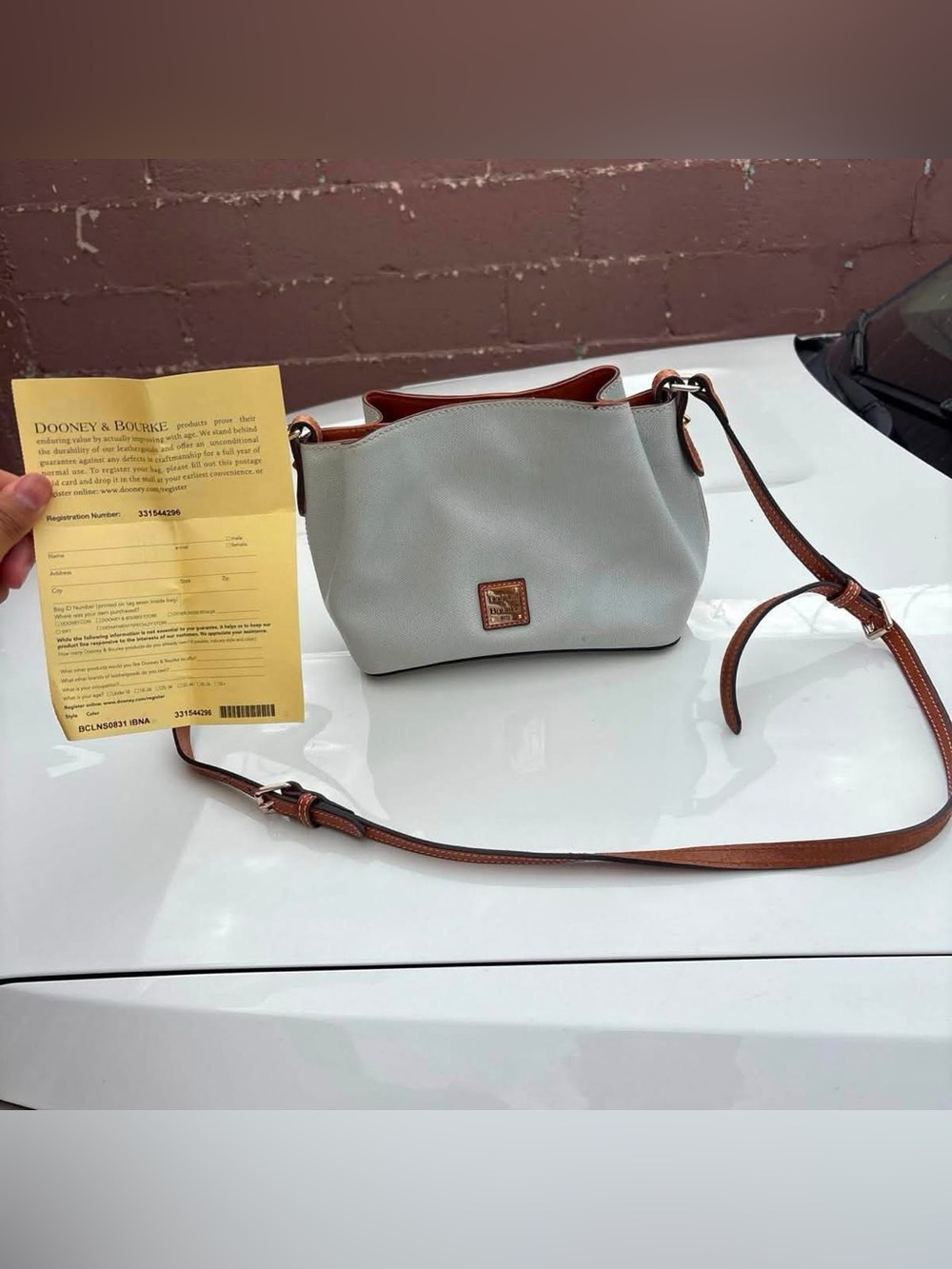 White Dooney & Bourke Mini Barlow Crossbody with registration number paper